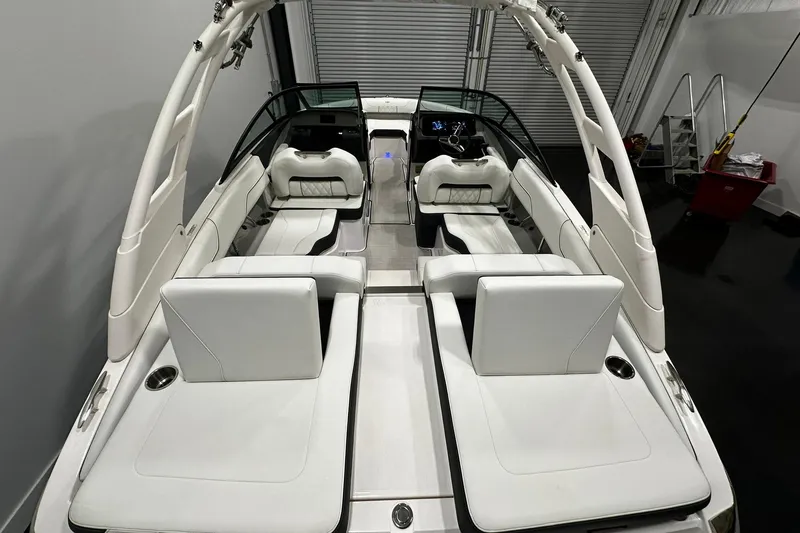 Slide: The Image of 2025 Regal LS2 boat interior with white seating and sleek design in a showroom. - 5