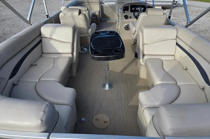 Slide: The Image of 2017 Bennington 22 SSRX pontoon boat interior with beige seating and central table. - 10