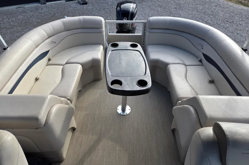 Slide: The Image of 2017 Bennington 22 SSRX pontoon boat interior with beige seating and central table. - 9