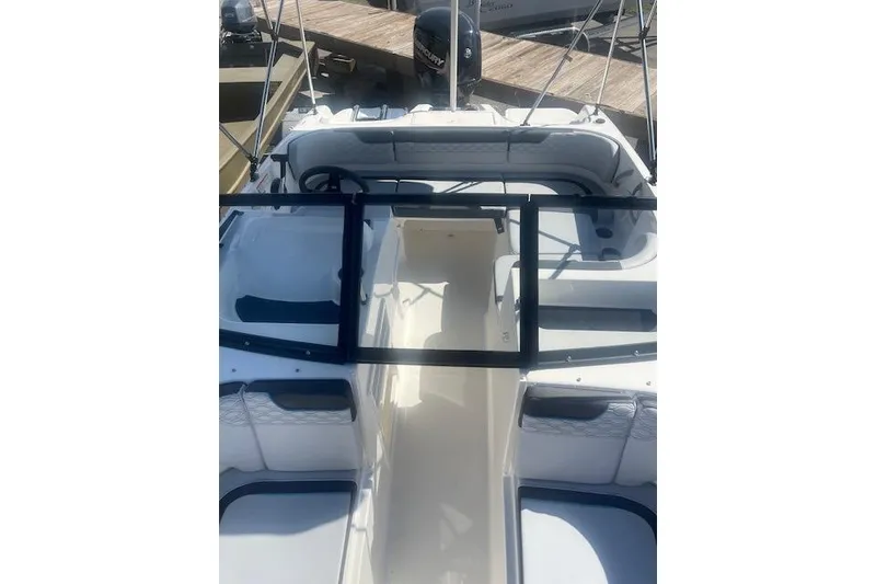 Slide: The Image of 2026 Bayliner M17 boat interior with seating and steering wheel, docked at marina. - 8