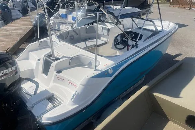 Slide: The Image of 2026 Bayliner M17 boat with blue and white design, docked with Mercury outboard motor. - 1