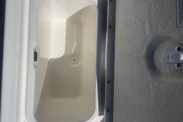 Slide: The Image of Storage compartment of a 2026 Bayliner M17 boat, featuring a white interior. - 19