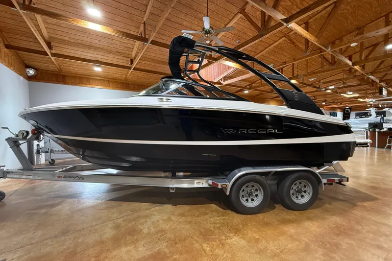 Slide: The Image of 2026 Regal LS2 boat on trailer in wooden-ceiling showroom. - 12