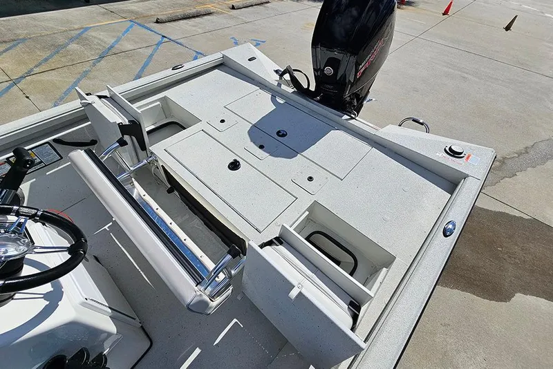 Slide: The Image of 2026 Ranger RB190 boat interior with storage compartments and motor, parked on concrete. - 14