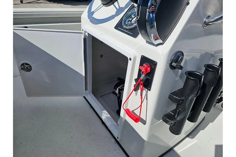 Slide: The Image of 2026 Ranger RB190 boat console with open storage, steering wheel, and rod holders. - 17