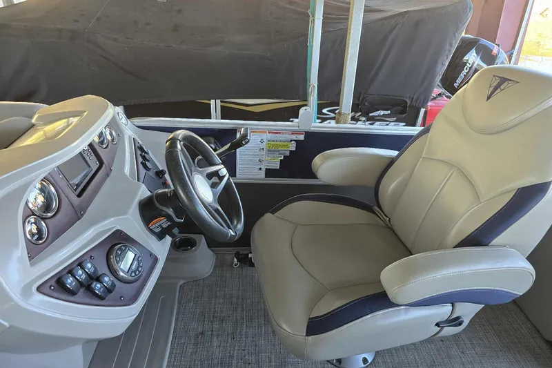 Slide: The Image of 2023 Trifecta 24 RFE boat interior with steering wheel and captain's chair. - 10