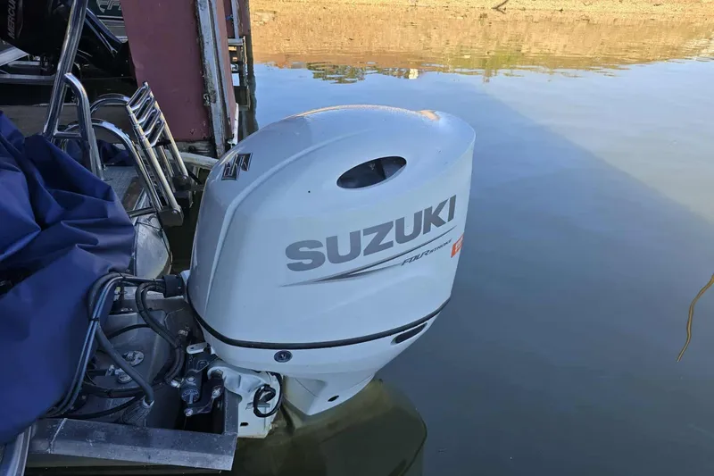 Slide: The Image of 2023 Trifecta 24 RFE with Suzuki outboard motor on calm water. - 5