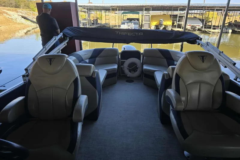 Slide: The Image of 2023 Trifecta 24 RFE pontoon boat interior with luxurious seating and lake view. - 6