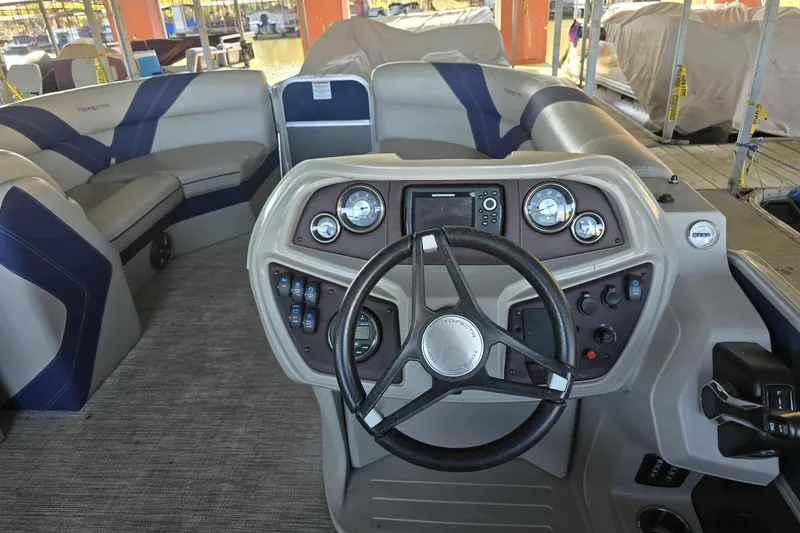 Slide: The Image of Interior view of 2023 Trifecta 24 RFE pontoon boat with steering wheel and dashboard controls. - 7
