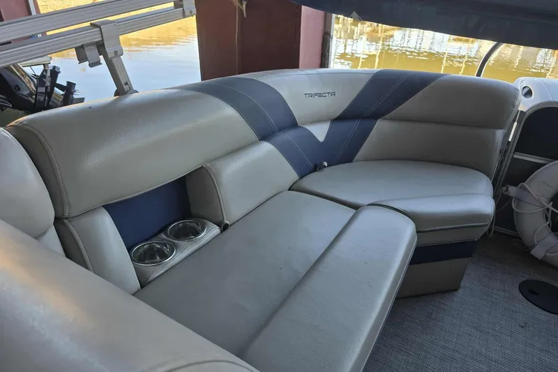 Slide: The Image of 2023 Trifecta 24 RFE boat interior with cushioned seating and cup holders. - 9