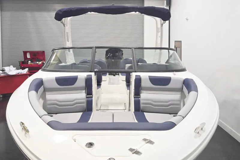 Slide: The Image of 2026 Regal LX2 boat interior with blue and gray seating in a showroom. - 3