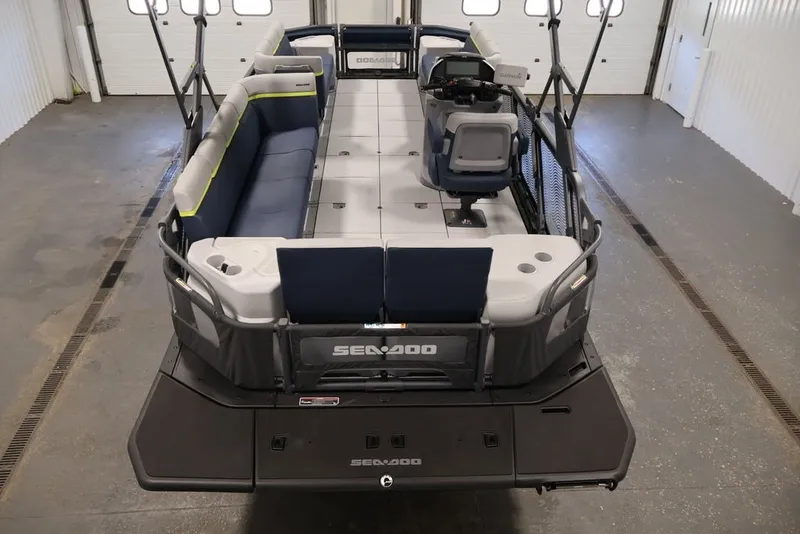Slide: The Image of 2025 Sea-Doo Switch Cruise Limited 21 pontoon boat in a garage, showcasing spacious seating. - 19