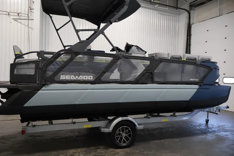 Slide: The Image of 2025 Sea-Doo Switch Cruise Limited 21 pontoon boat on trailer in indoor setting. - 2