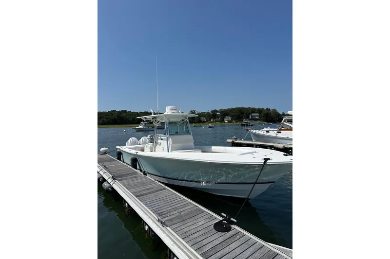Slide: The Image of 2005 Regulator 32 Forward Seating boat docked on a sunny day. - 2