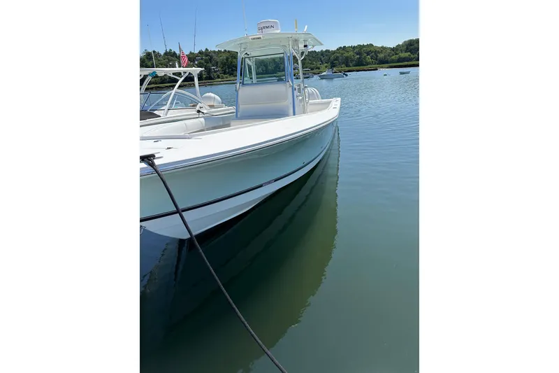 Slide: The Image of 2005 Regulator 32 Forward Seating boat docked on calm water. - 4