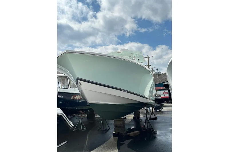 Slide: The Image of 2005 Regulator 32 Forward Seating boat displayed outdoors under a cloudy sky. - 5