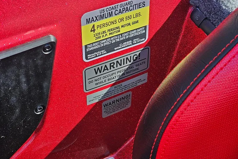 Slide: The Image of Warning labels on red Phoenix 819 ZXL boat, 2026 model, showing capacity and safety instructions. - 23