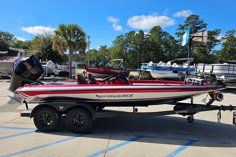 Slide: The Image of 2026 Phoenix 819 ZXL boat on trailer, parked outdoors under clear blue sky. - 6