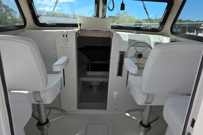 Slide: The Image of Interior of 2026 Parker 257 Explorer boat with white seating and steering wheel. - 14