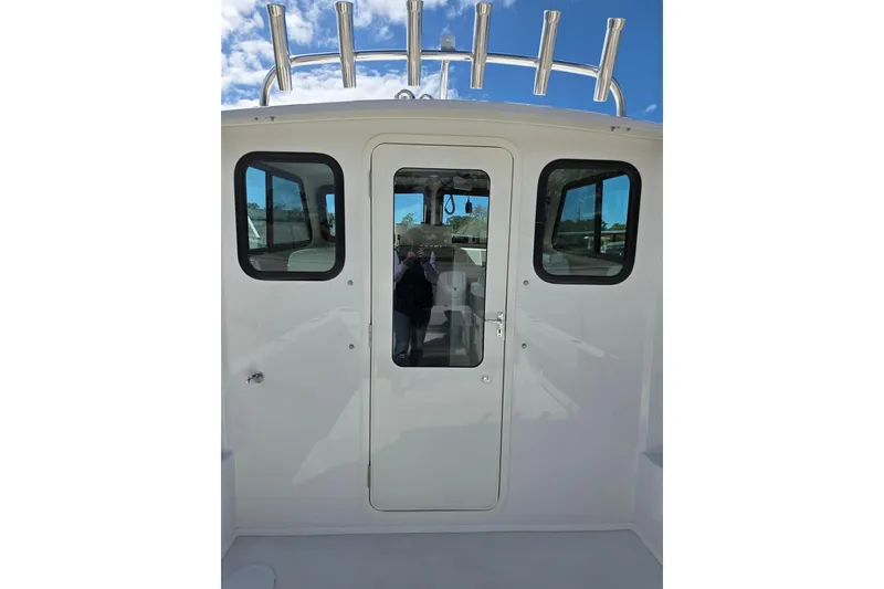Slide: The Image of 2026 Parker 257 Explorer boat cabin door with windows and rod holders. - 25