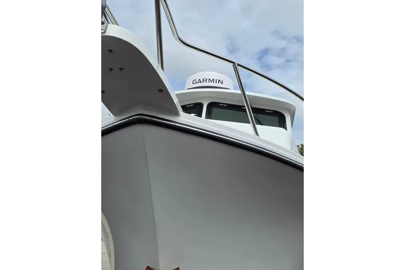Slide: The Image of 2026 Parker 257 Explorer boat with Garmin equipment, viewed from below against a cloudy sky. - 35