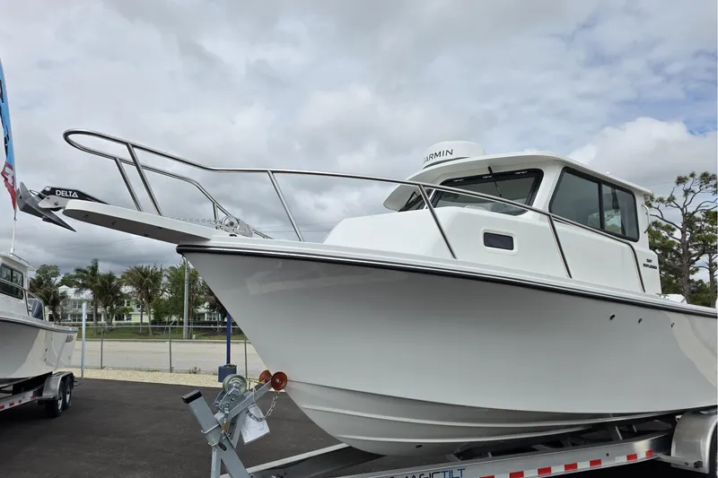 Slide: The Image of 2026 Parker 257 Explorer boat on trailer under cloudy sky. - 37