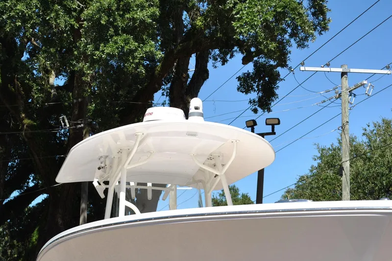 Slide: The Image of 2016 Regulator 34 Center Console boat with T-top, trees, and power lines in background. - 12