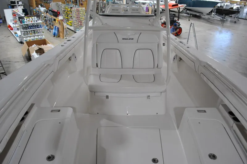 Slide: The Image of 2016 Regulator 34 Center Console boat interior in showroom with seating and storage. - 15