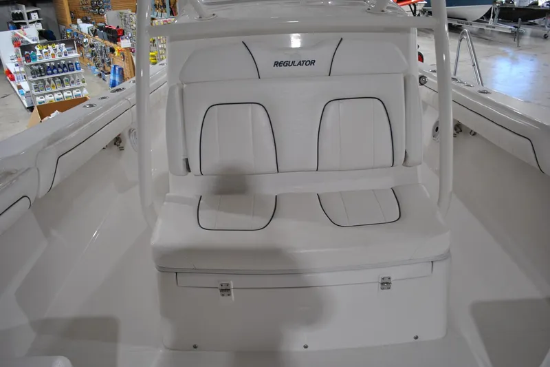 Slide: The Image of 2016 Regulator 34 Center Console boat interior with white seating and storage compartment. - 21