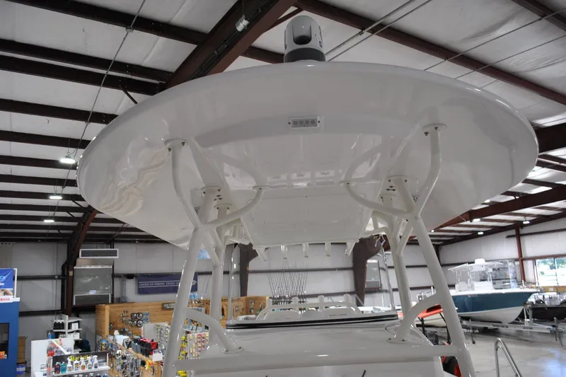 Slide: The Image of 2016 Regulator 34 Center Console boat in showroom, showcasing T-top structure. - 22