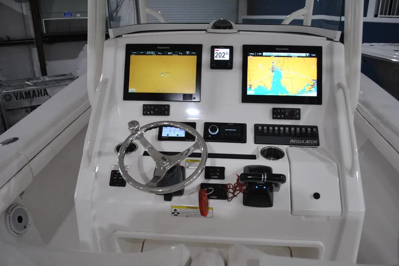 Slide: The Image of 2016 Regulator 34 Center Console helm with dual navigation screens and steering wheel. - 23