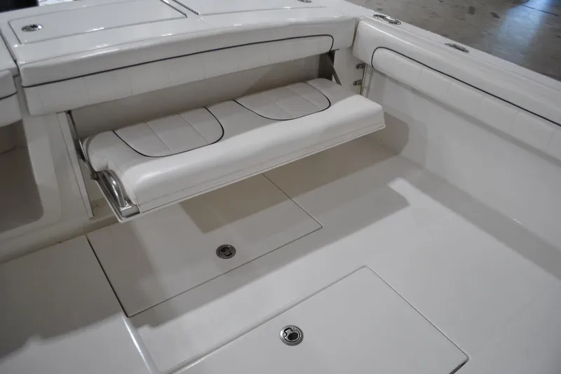 Slide: The Image of 2016 Regulator 34 Center Console boat interior with foldable seating and storage compartments. - 51