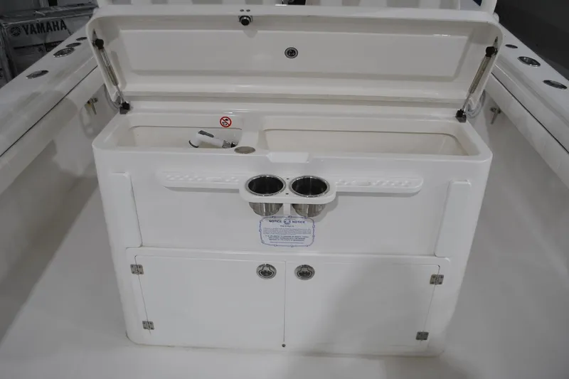 Slide: The Image of 2016 Regulator 34 Center Console boat with open storage compartment and cup holders. - 52