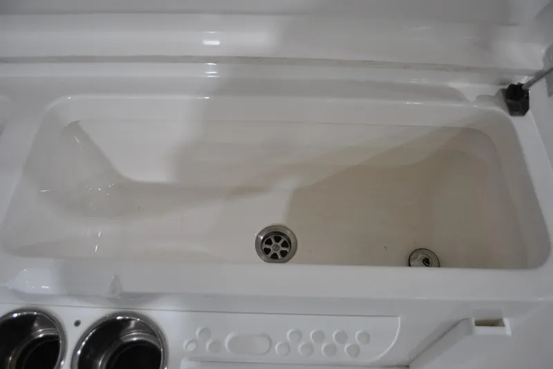 Slide: The Image of 2016 Regulator 34 Center Console boat interior compartment with drain and cup holders. - 54