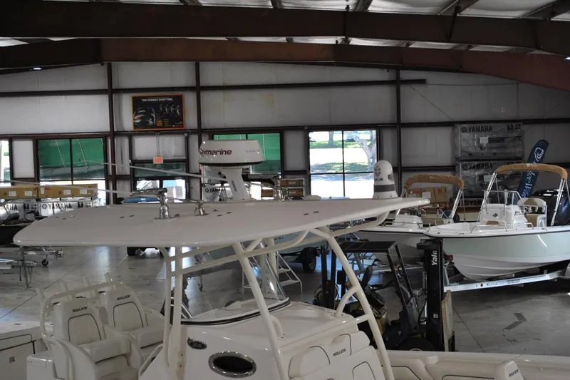 Slide: The Image of 2016 Regulator 34 Center Console boat in a showroom with other boats. - 79