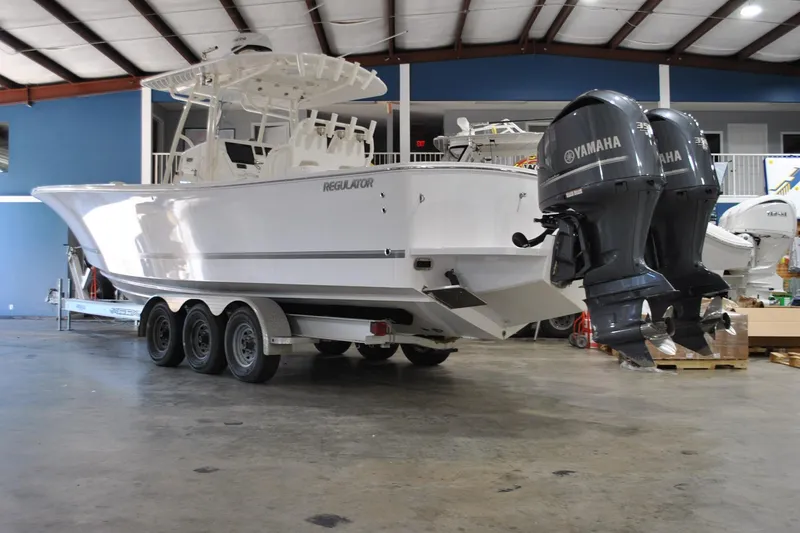Slide: The Image of 2016 Regulator 34 Center Console boat with twin Yamaha engines in a showroom. - 85