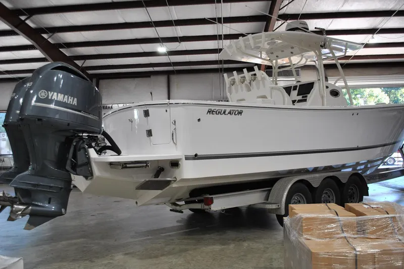 Slide: The Image of 2016 Regulator 34 Center Console boat with Yamaha outboard in a warehouse setting. - 86