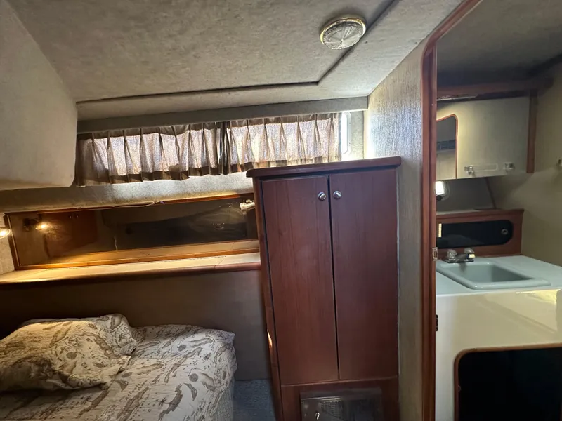 Slide: The Image of 1987 Bayliner 3888 Motoryacht interior with bed, cabinet, and sink area. - 10