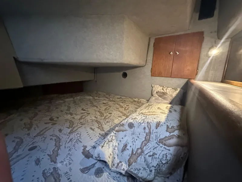 Slide: The Image of Cozy cabin interior of 1987 Bayliner 3888 Motoryacht with patterned bedding and wooden cabinets. - 11