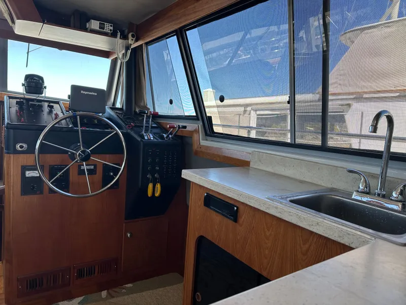 Slide: The Image of 1987 Bayliner 3888 Motoryacht interior with steering wheel, control panel, and sink. - 13