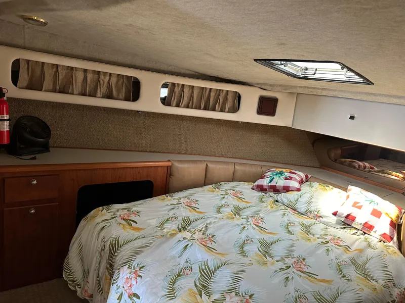 Slide: The Image of 1987 Bayliner 3888 Motoryacht cabin with floral bedding, wood cabinetry, and natural light. - 16