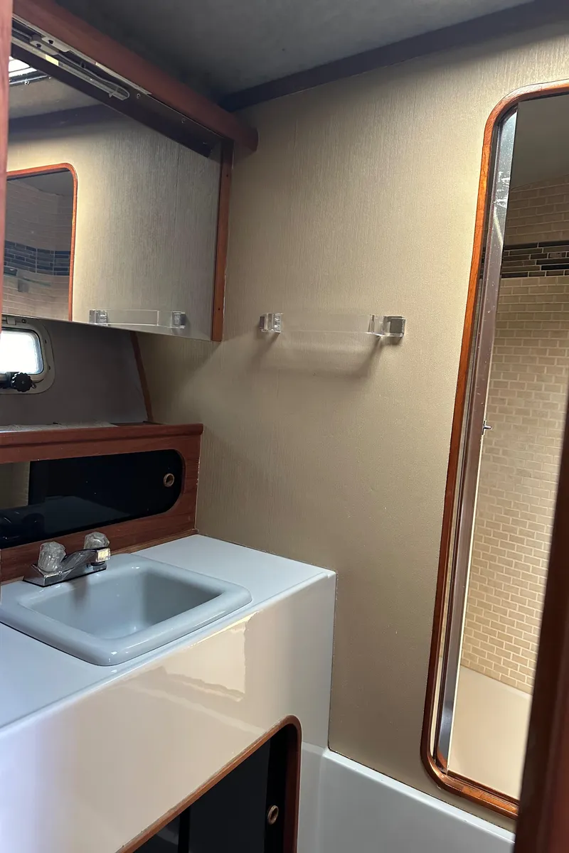 Slide: The Image of 1987 Bayliner 3888 Motoryacht bathroom with sink, mirror, and wooden accents. - 19