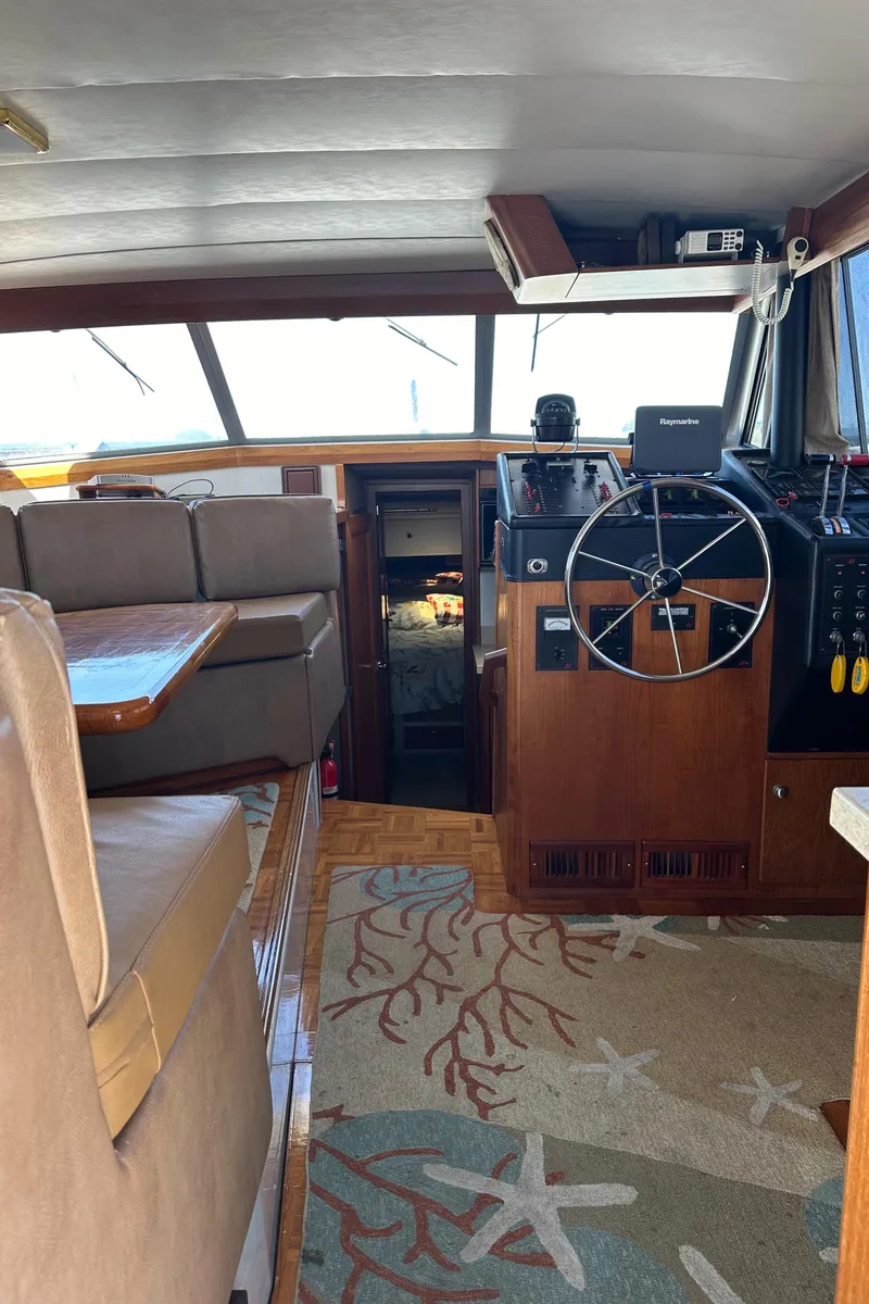 Slide: The Image of Interior of 1987 Bayliner 3888 Motoryacht with helm, seating, and nautical-themed carpet. - 27