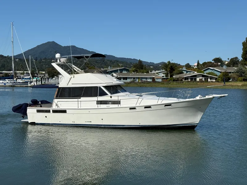 Slide: The Image of 1987 Bayliner 3888 Motoryacht cruising on calm waters with scenic background. - 3