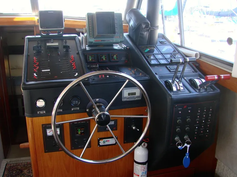 Slide: The Image of 1987 Bayliner 3888 Motoryacht helm with steering wheel, controls, and navigation equipment. - 5