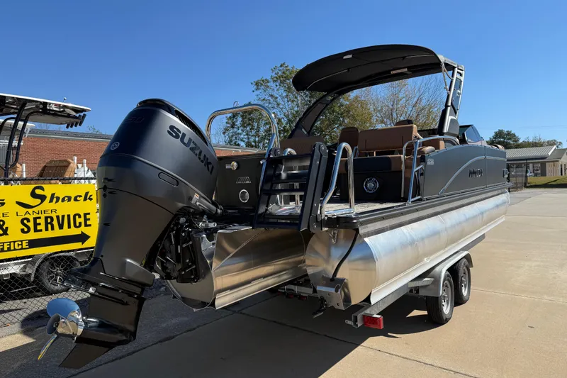 Slide: The Image of 2026 Avalon Catalina Quad Lounger Windshield boat on trailer, featuring Suzuki outboard motor. - 12