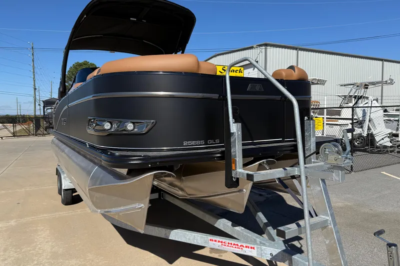 Slide: The Image of 2026 Avalon Catalina Quad Lounger Windshield boat on trailer, outdoor display. - 2