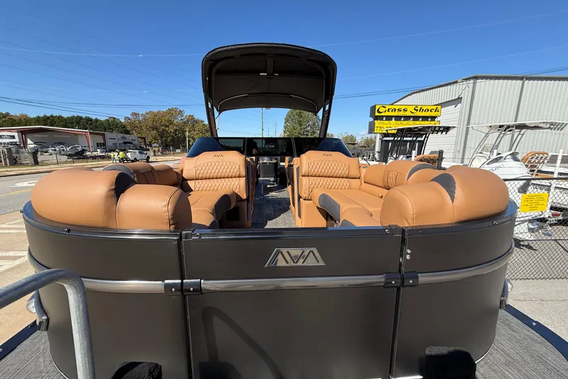 Slide: The Image of 2026 Avalon Catalina Quad Lounger Windshield boat with luxurious tan seating, displayed outdoors. - 21