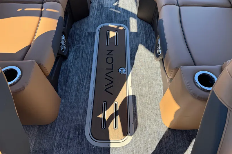 Slide: The Image of 2026 Avalon Catalina Quad Lounger Windshield interior with tan seating and cup holders. - 66