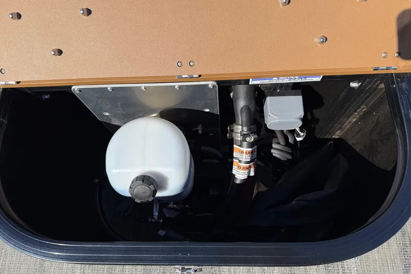 Slide: The Image of 2026 Avalon Catalina Quad Lounger Windshield storage compartment with equipment and wiring. - 68